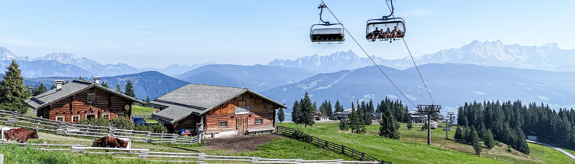 The Starjet mountain lift with a view of a mountain pasture with cows and mountains in Flachau   The Starjet mountain lift with a view of a mountain pasture with cows and mountains in Flachau from Snow Space Salzburg