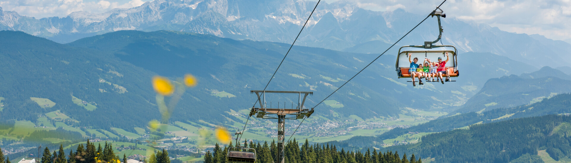 Family on lift in snow space region in summer 