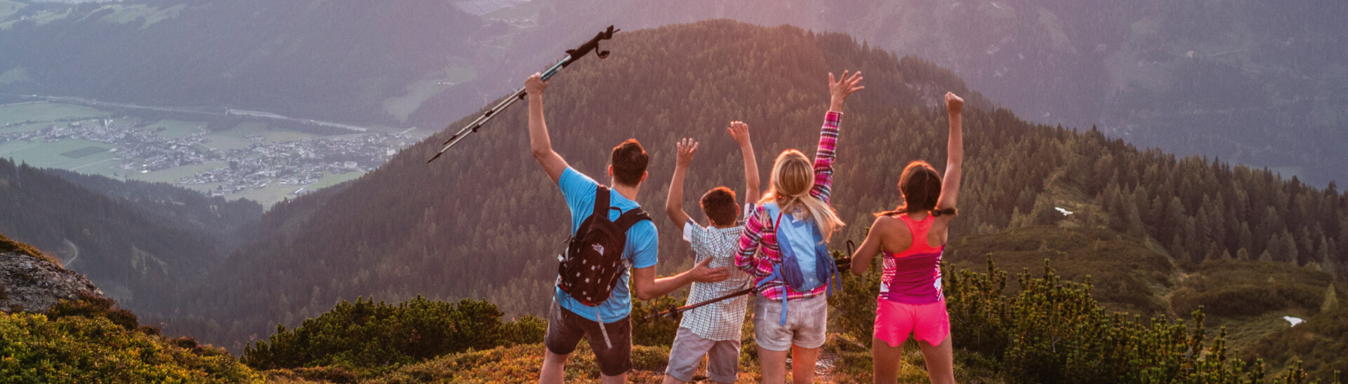 Four friends on the summit with a view into the valley 