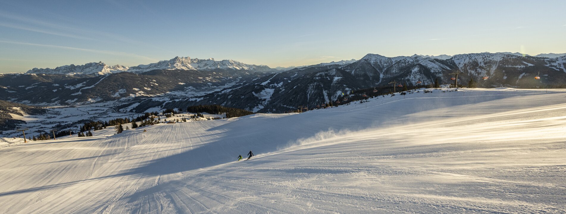 Frisch präparierte Pisten bei Sonnenaufgang im Skigebiet von Snow Space Salzburg