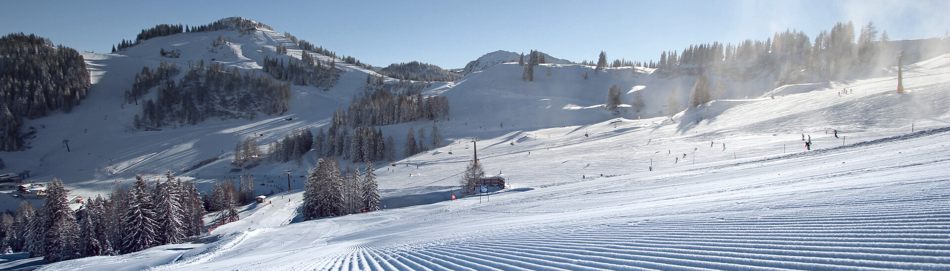 Frisch präparierte Piste in St. Johann-Alpendorf im Skigebiet Snow Space Salzburg bei Sonnenschein mit Blick in Richtung Sonntagskogel | © Alpendorf Bergbahnen AG