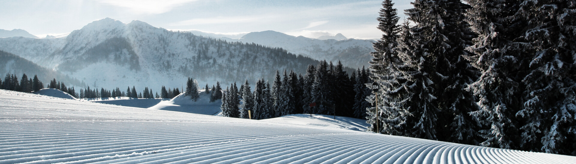 View to the just recently prepared slopes of the ski area St. Johann with sunshine