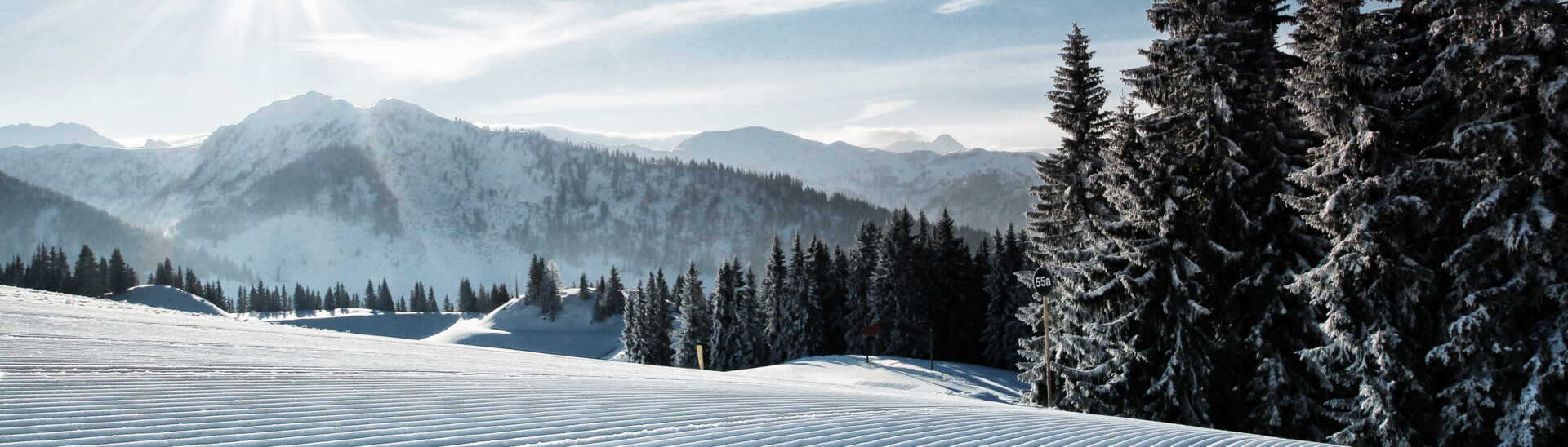 View to the just recently prepared slopes of the ski area St. Johann with sunshine