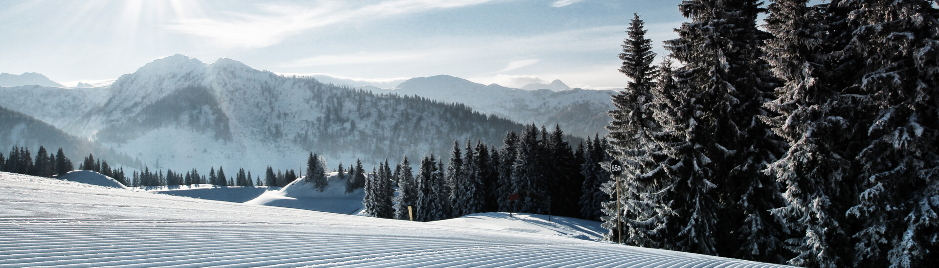 Blick auf die frisch präparierten Pisten des Skigebiets St. Johann bei Sonnenshine