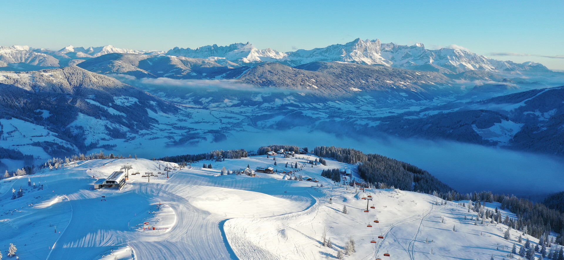 Panoramaaufnahme von der Ortschaft Flachau mit einer Piste von Snow Space Salzburg im Vordergrund