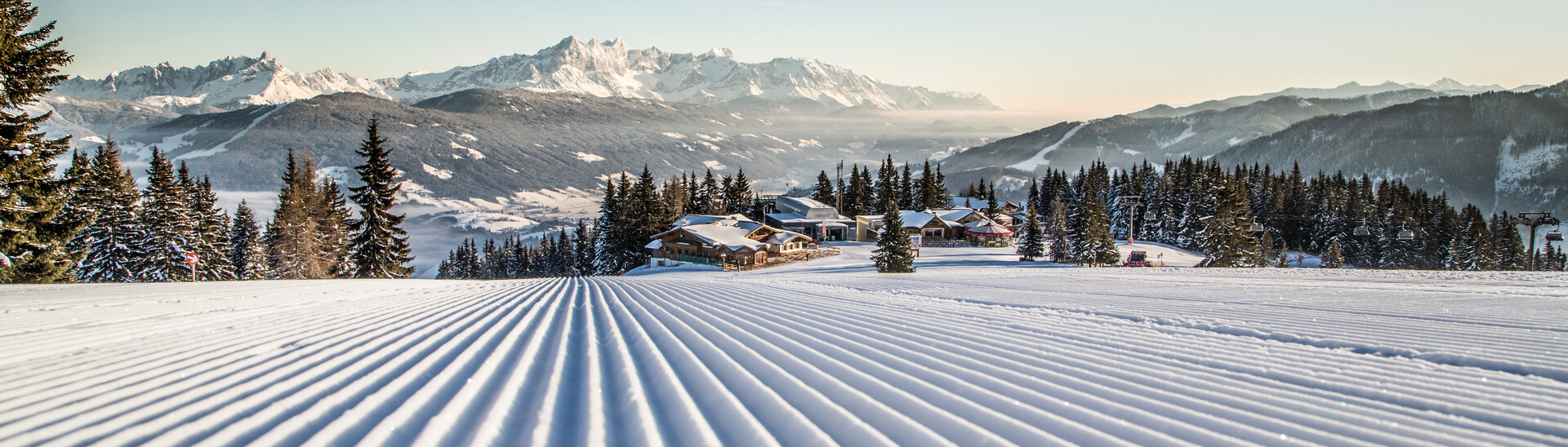 Blick auf Flachau über die frisch präparierte Piste im Skigebiet Snow Space Salzburg mit 120 Pistenkilometer.  | © Bergbahnen Flachau GmbH