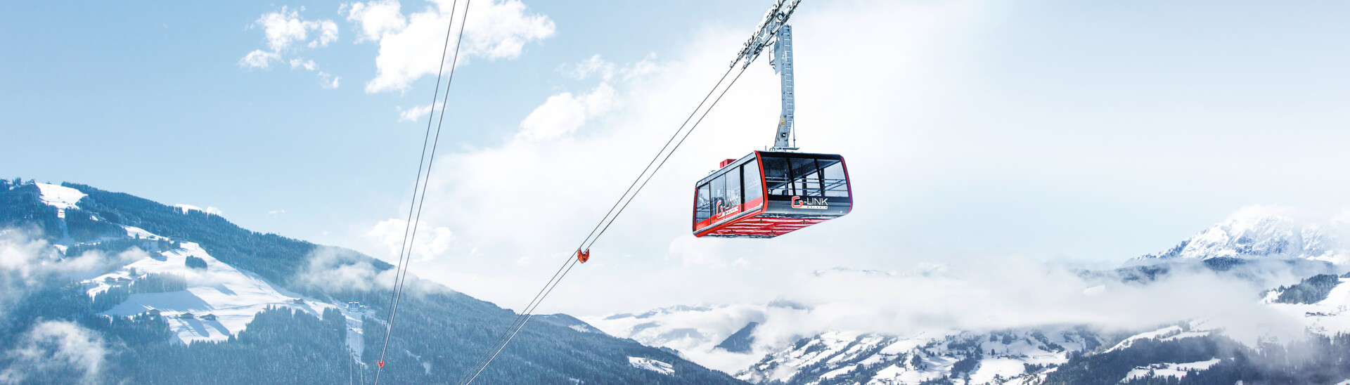 Blick auf G-LINK, eine der größten Pendelbahnen der Welt in Richtung des tiefverschneiten Tals in Wagrain im Snow Space Salzburg